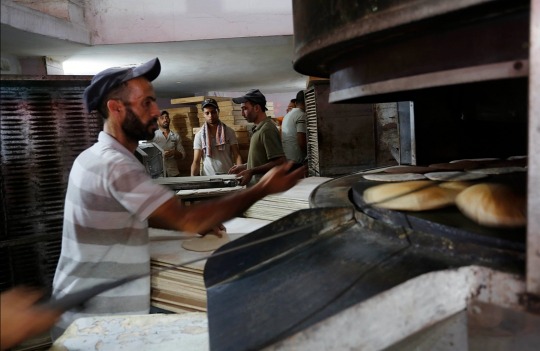 بالصور.. عشرات المواطنين يصطفون أمام أحد المخابز وسط قطاع غزة لشراء الخبز